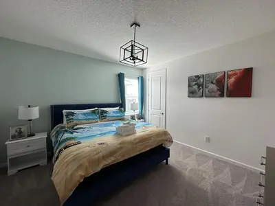 a bedroom with a bed and a chandelier at 2476 SHANTI DRIVE 12BED in Kissimmee