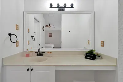 a bathroom with a sink and a large mirror at 2722 CLUB CORTILE UNIT B 3BED in Kissimmee