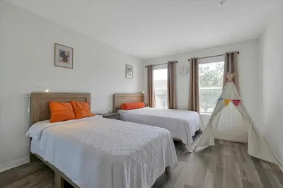 a bedroom with two beds and a window at 2722 CLUB CORTILE UNIT B 3BED in Kissimmee