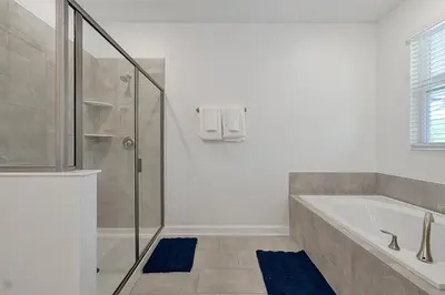 a bathroom with a tub and a glass shower at 2968 PENELOPE LOOP 10 BED in Kissimmee