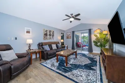 a living room with a couch and a flat screen tv at 4820 JAMAICA LANE 4BED in Kissimmee