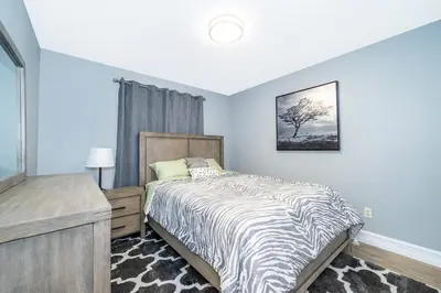 a bedroom with a bed with a black and white comforter at 4820 JAMAICA LANE 4BED in Kissimmee
