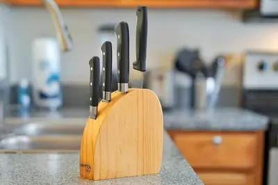 a wooden knife block with four knives on a kitchen counter at 8460 CRYSTAL COVE LOOP 3BED in Kissimmee