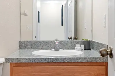 a bathroom with a sink and a mirror at 8460 CRYSTAL COVE LOOP 3BED in Kissimmee