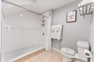 a white bathroom with a shower and a toilet at 4005 SAN SABASTIAN DRIVE 3BED in Kissimmee