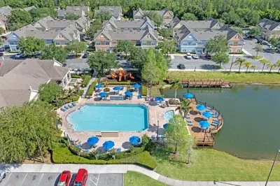 an aerial view of a pool with chairs and umbrellas at 4005 SAN SABASTIAN DRIVE 3BED in Kissimmee