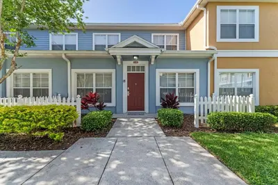 a house with a red door and a white fence at 4005 SAN SABASTIAN DRIVE 3BED in Kissimmee