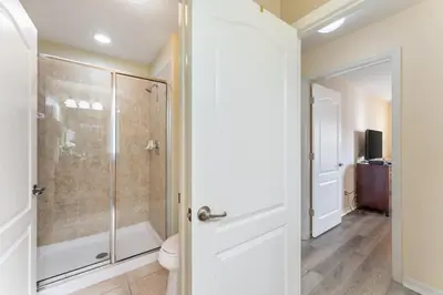 a bathroom with a shower and a toilet at 4BR Retreat with Resort Access and Pool in Kissimmee