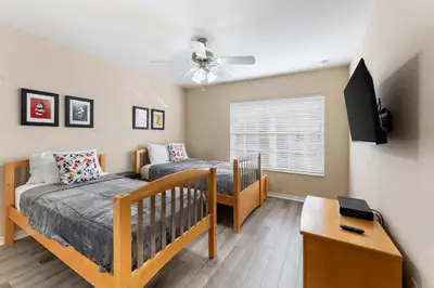 a bedroom with two bunk beds and a tv at 4BR Retreat with Resort Access and Pool in Kissimmee