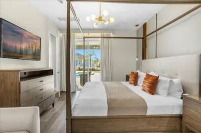 a bedroom with a large bed and a tv at Awsome 8 Bd 6.5 Ba Sleeps 20 Encore in Orlando