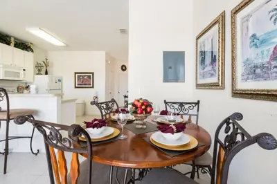 a kitchen and dining room with a wooden table and chairs at Windsor Hills Getaway: 3BR, Pool, Near Disney in Orlando