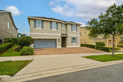 a large house with a garage on a street at 8 Bedroom 6.5 Bathroom Encore at Reunion 7644 in Orlando