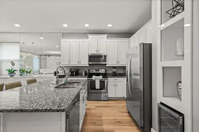 a kitchen with white cabinets and stainless steel appliances at 8 Bedroom 6.5 Bathroom Encore at Reunion 7644 in Orlando