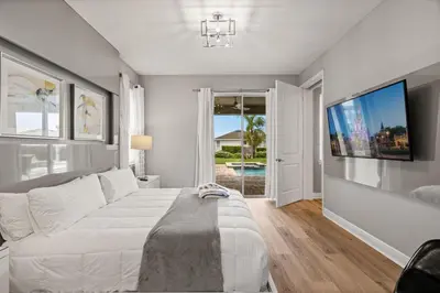 a bedroom with a large bed and a flat screen tv at 8 Bedroom 6.5 Bathroom Encore at Reunion 7644 in Orlando
