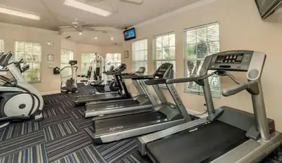 a gym with several treadmills and cardio machines at Your Cozy 3 BD Home w Private Hot Tub & BBQ Gril in Kissimmee