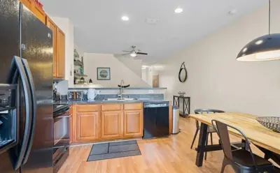 a kitchen with a table and a stainless steel refrigerator at Cozy Home with 3BD & BBQ Grill in Orlando