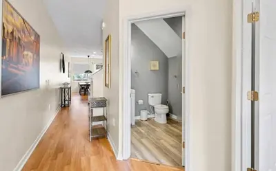 a hallway with a bathroom with a toilet and a staircase at Cozy Home with 3BD & BBQ Grill in Orlando