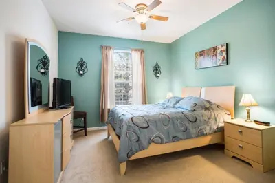 a bedroom with a bed and a flat screen tv at Windsor Palms Condo | Pool, Spa & Near Disney in Kissimmee
