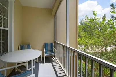a balcony with a table and chairs and a window at Windsor Palms Condo | Pool, Spa & Near Disney in Kissimmee