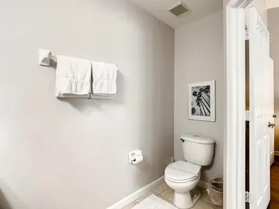 a bathroom with a toilet and towels on the wall at Windsor Palms Townhome w/Private Pool Near Disney in Kissimmee