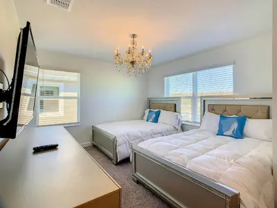 a bedroom with two beds and a chandelier at Lovely Themed Room with Private Pool in Kissimmee