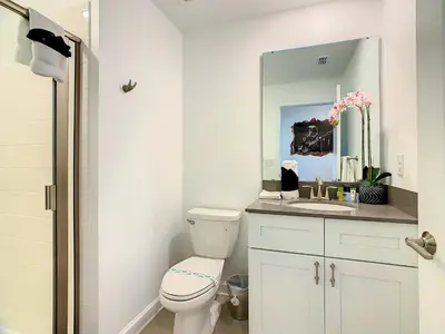 a bathroom with a toilet and a sink and a mirror at Lovely Themed Room with Private Pool in Kissimmee
