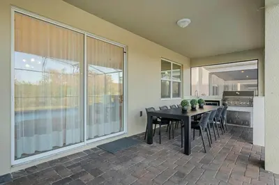 a dining room with a black table and chairs at Storey Lake, 24 hóspedes, 9Q, piscina e vista lago in Kissimmee