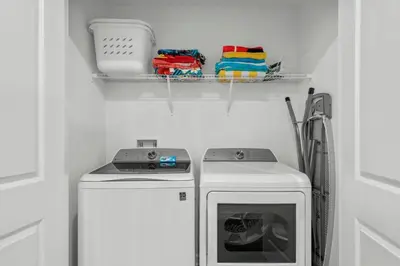 a laundry room with a washing machine and a shelf at Storey Lake, 24 hóspedes, 9Q, piscina e vista lago in Kissimmee
