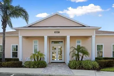 a house with palm trees in front of it at 12 min da Disney • Casa 3 Q c/ Resort in Kissimmee