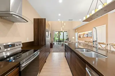 a large kitchen with a sink and a stove at Magic Village 4 suítes 8 min da Disney perto da 192 in Orlando