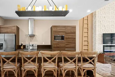 a kitchen with a table with chairs and a refrigerator at Magic Village 4 suítes 8 min da Disney perto da 192 in Orlando