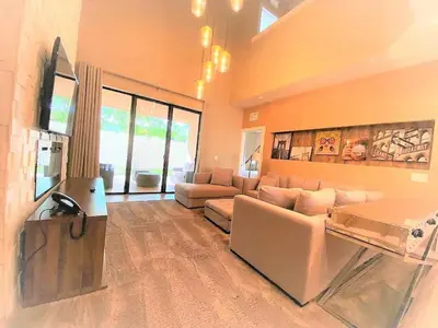 a large living room with a couch and a television at Magic Village 4 suítes 8 min da Disney perto da 192 in Orlando