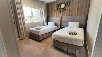 a hotel room with two beds and a window at 3053 Magic Village - Jacuzzi excepcional, a 8 minutos da Disney in Orlando