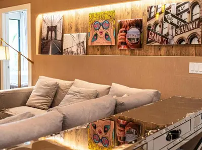 a couch in a room with pictures on the wall at Magic Village: charme e conforto a 8 min da Disney in Orlando
