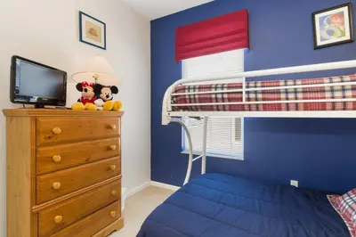 a bedroom with a bunk bed and a blue wall at Windsor Palms Villa: Pool & Close to Disney in Kissimmee