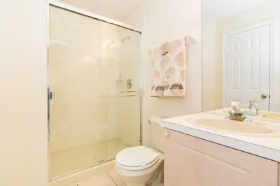 a bathroom with a shower and a toilet and a sink at Windsor Palms Villa: Pool & Close to Disney in Kissimmee