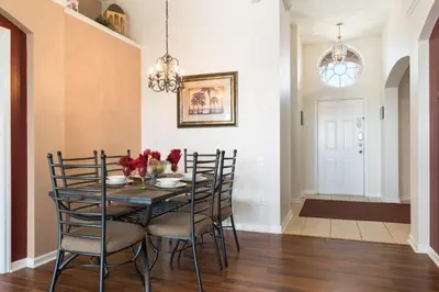 a dining room with a black table and chairs at Windsor Palms Villa: Pool & Close to Disney in Kissimmee