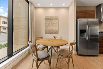 a kitchen with a table and a refrigerator at 7562 Magic Village: 4 Suítes, 8 Hóspedes, Apenas 8 Minutos da Disney! in Orlando