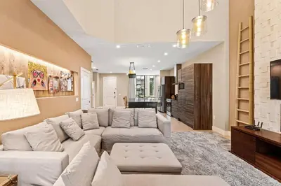a living room with a large couch and a tv at 7562 Magic Village: 4 Suítes, 8 Hóspedes, Apenas 8 Minutos da Disney! in Orlando