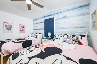 two beds in a bedroom with hello kitty posters on the wall at New! Family cottage near Disney-Sleep 6 in Kissimmee