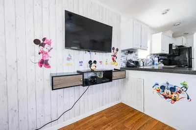 a kitchen with a flat screen tv on the wall at New! Family cottage near Disney-Sleep 6 in Kissimmee