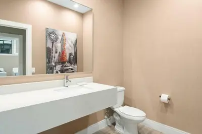 a bathroom with a sink and a toilet and a mirror at 6 min da Disney • Casa Moderna 4 Suítes c/ BBQ in Orlando