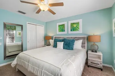 a bedroom with a bed with blue walls and a ceiling fan at 7774 Basnett Circle in Kissimmee