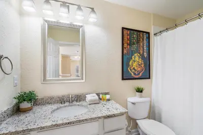 a bathroom with a toilet and a sink and a mirror at 7774 Basnett Circle in Kissimmee