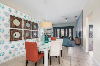 a dining room and living room with a table and chairs at 7774 Basnett Circle in Kissimmee