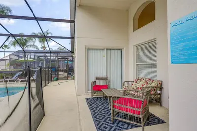 a patio with a table and chairs and a pool at 9 Mi to Disney Home with Pool Table and Water Views! in Kissimmee