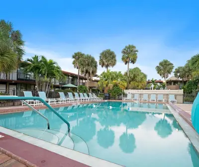 a swimming pool at a resort with chairs and palm trees at Magic Tree Resort by Coolvacay in Orlando
