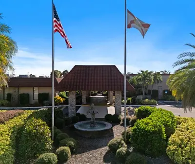 two flags flying in front of a building with a fountain at Magic Tree Resort by Coolvacay in Orlando