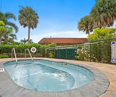 a small swimming pool with a fence and palm trees at Magic Tree Resort by Coolvacay in Orlando