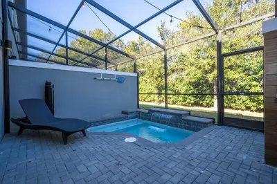 a swimming pool in a glass house with a chair at Beautiful 4BD home Themed Pool and Grill 4403 in Kissimmee